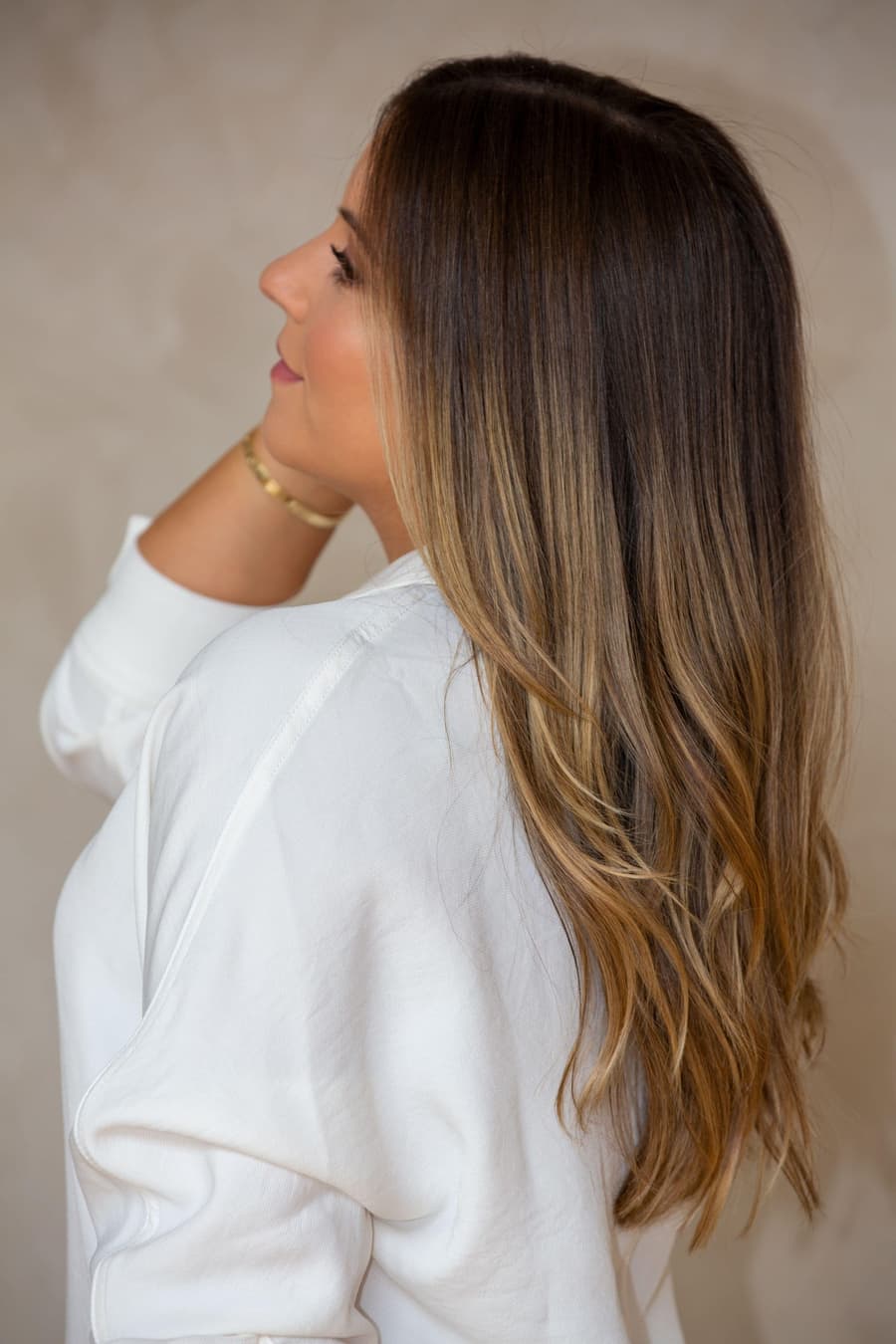 Woman with long glossy brunette hair in a white shirt